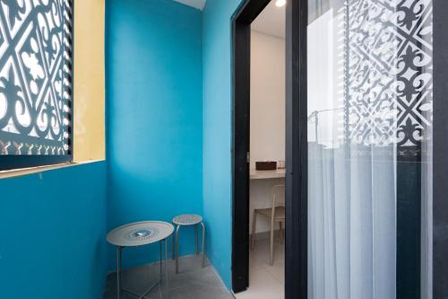 a blue room with stools in front of a glass door at Sans Hotel Elrose Place in Samarinda