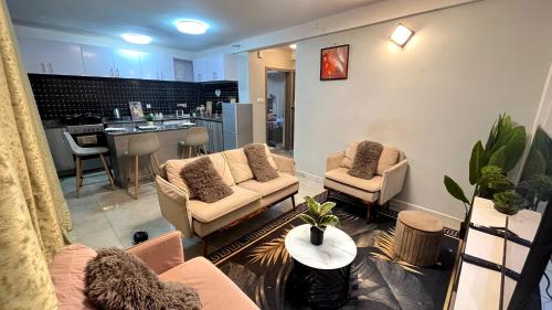 salon z kanapą i krzesłami oraz kuchnia w obiekcie Dream Home Design w mieście Mbalngong
