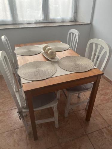 a wooden table with chairs and plates on it at Liencres Apartment in Liencres