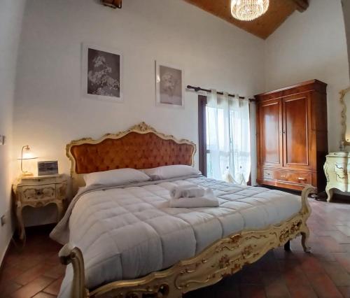 a bedroom with a large bed with a wooden headboard at Ca' Bianca in Lugo