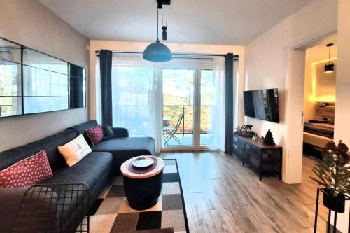 una sala de estar con un sofá y una mesa en FOREST SIDE Apartmani, en Divčibare