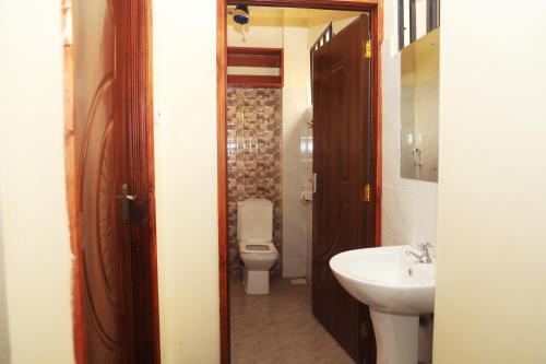 a bathroom with a toilet and a sink at PALISADES homes in Voi