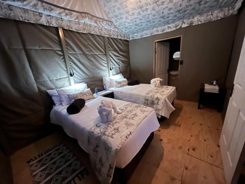 a bedroom with two beds with white sheets at Jacil Riverside Accommodation in Hekpoort