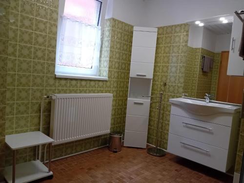 a bathroom with a sink and a mirror and a window at Gästehaus Dietrich in Bad Sooden-Allendorf