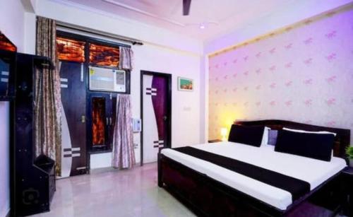 a bedroom with a bed and a large window at Pushkar Prime Resort in Pushkar