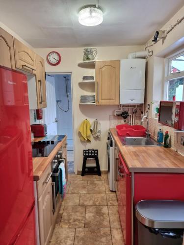 a small kitchen with red cabinets and a sink at Canterbury within the city wall - Sleeps 7 - Pet-Friendly with Garden in Canterbury