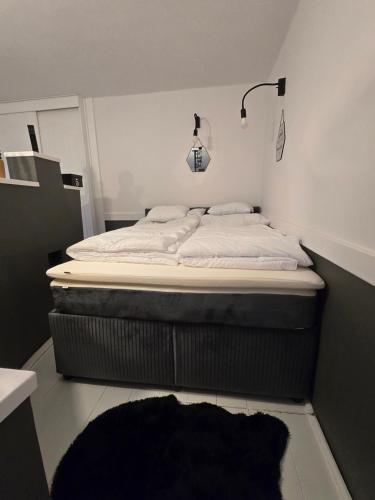 a large bed in a room with a black rug at Ákos Apartman in Székesfehérvár