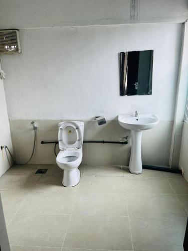 a bathroom with a toilet and a sink at Relax On Plus Kelaniya in Kelaniya