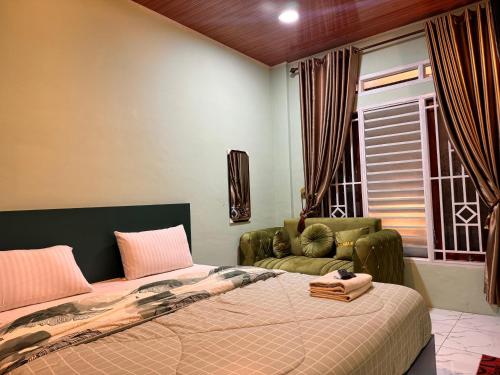 a bedroom with a bed and a chair and a window at Cio Adventure Hotel in Berastagi