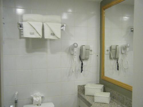a bathroom with a phone and a toilet and a mirror at Fortaleza 703--Fortaleza 713 in Fortaleza
