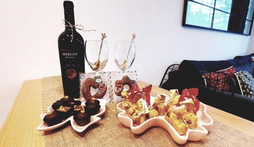 un tavolo con due piatti di cibo e una bottiglia di vino di FOREST SIDE Apartmani a Divčibare