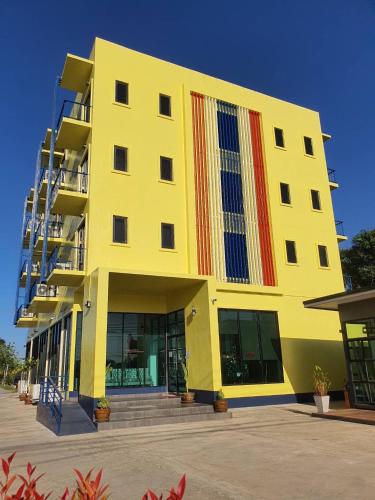 a yellow building with red and blue stripes on it at T-NEE Hotel@Udon in Udon Thani