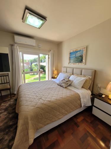 a bedroom with a large bed with a window at Pousada Casa Thede in São Salvador