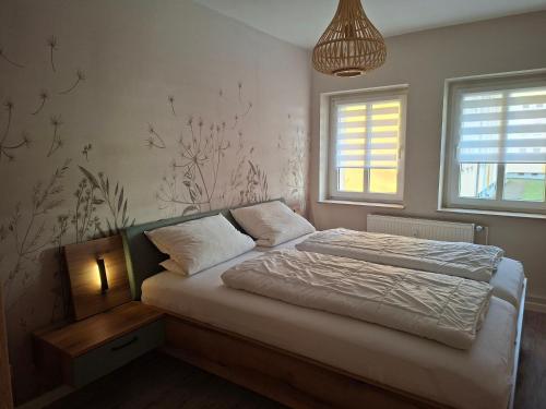 a bedroom with a bed and a lamp and windows at Stadtrand Apartment in Markkleeberg