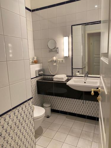 a bathroom with a sink and a toilet and a mirror at Schlosshotel Ziethen in Kremmen
