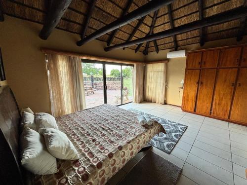 a bedroom with a bed and a large window at De Rust Private Nature Reserve in Odendaalsrus