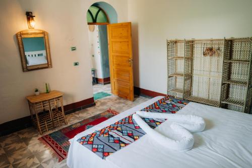 a bedroom with a bed with a large white snake on it at Harmonia House in Al Karnak