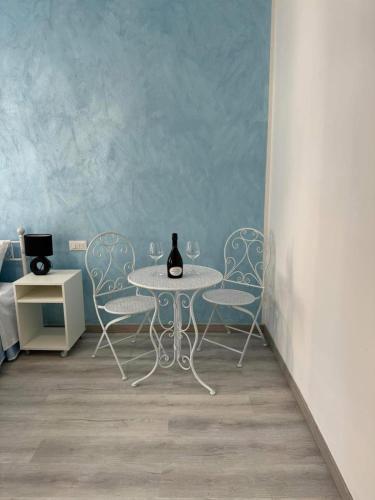 a table with two chairs and a bottle of wine on it at Frida Apartment in Chioggia
