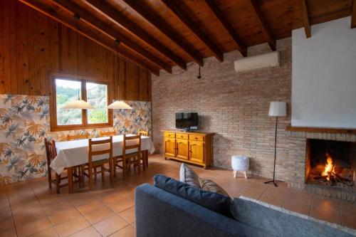 a living room with a table and a fireplace at Casa de Madera I - Naturaleza y Experiencias in Bicorp