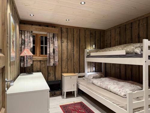 a bedroom with two bunk beds and a desk at Large cottage with beautiful view in Trysil in Trysil