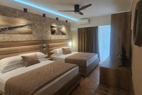 a hotel room with two beds and a ceiling fan at Resort Comfort - Long Beach in Ulcinj