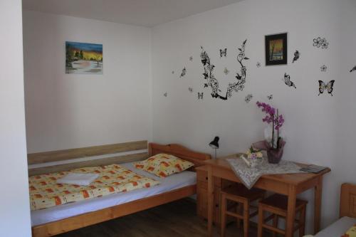 a small bedroom with a bed and a table at Enikő vendegház in Praid