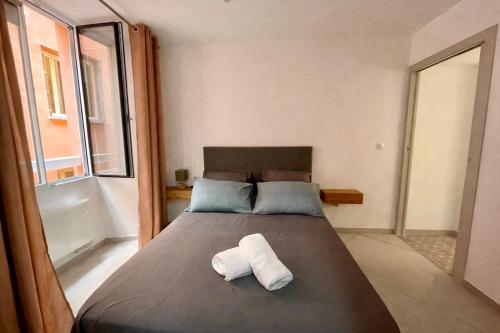 a bedroom with a large bed with two towels on it at Appartement T3 Place du Marché in Bastia