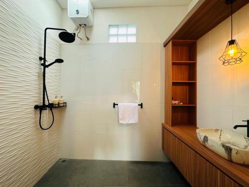 a bathroom with a tub and a sink and a shower at Golden Villa Lovina in Lovina