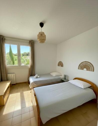 a bedroom with two beds and a window at Casa Dolce Giens - Parenthèse ensoleillée vue mer ! in Hyères