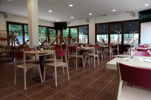 un restaurante con mesas, sillas y ventanas en Txikierdi Alde, en Oiartzun
