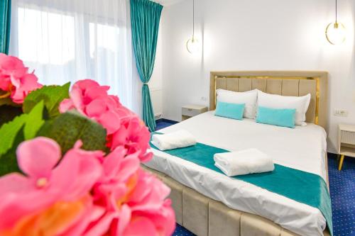 a bedroom with a bed with two pillows and pink flowers at Vila Manuela Techirghiol in Techirghiol