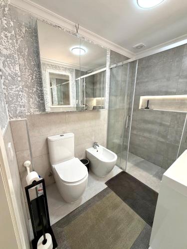 a bathroom with a toilet and a sink and a shower at Cozy Garden by the Beach in Playa del Cura