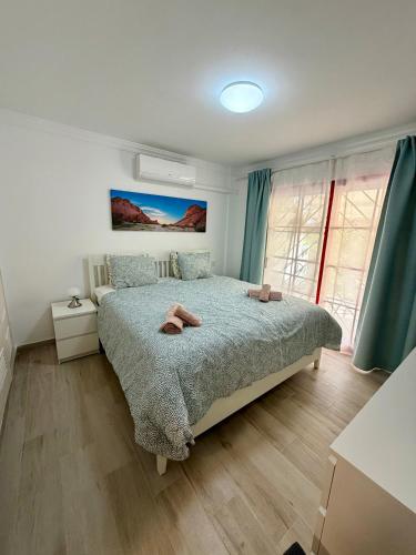 a bedroom with a bed with two towels on it at Cozy Garden by the Beach in Playa del Cura