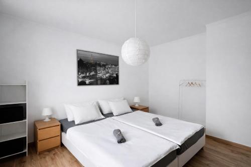 a white bedroom with a bed and a pendant light at Casa Silva in Pinhal Novo