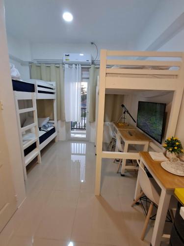 a room with two bunk beds and a desk at Urdaneta City Modern Condo in Bayaoas