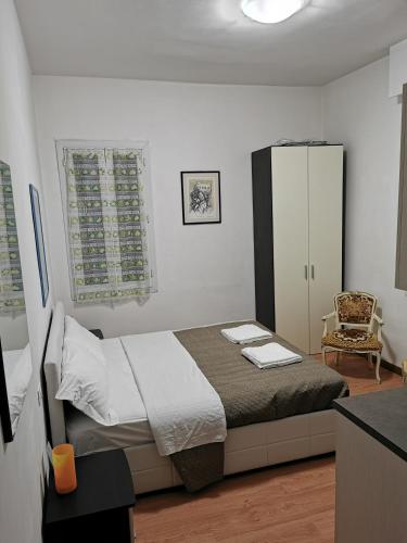 a small bedroom with a bed and a chair at Dimora Venice Station in Mestre