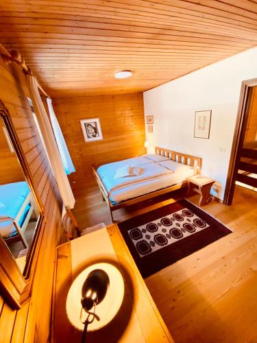 a small bedroom with a bed and a table at Apartament Loft Fiemme in Castello di Fiemme