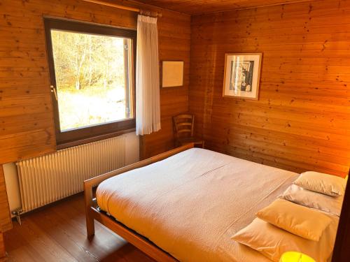 a bedroom with a bed in a wooden cabin at Apartament Loft Fiemme in Castello di Fiemme