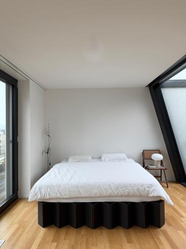 a bedroom with a white bed and a large window at Zurich City Appartement in Zurich