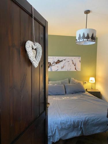 a bedroom with a bed and a heart sign on the door at Les Arnauds in Bardonecchia