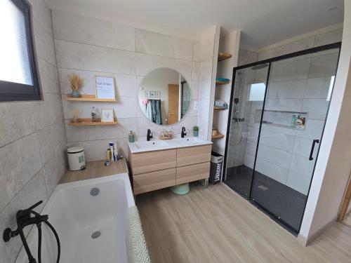 a bathroom with a tub and a sink and a shower at Villa Signature in Le Bosc
