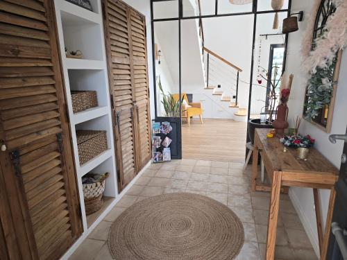 a hallway with a table and a large rug at Villa Signature in Le Bosc