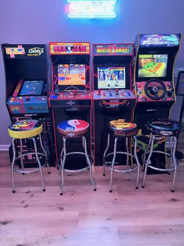 a room with four arcade games and two stools at Open Plan Arcade Home with Natural Hardwoods Sleeps 10 in Atlanta