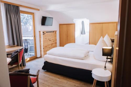 a hotel room with two beds and a window at Pension Bavaria in Mittenwald