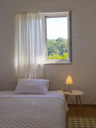 a bedroom with a bed and a window at Casa Allure in Višnjan