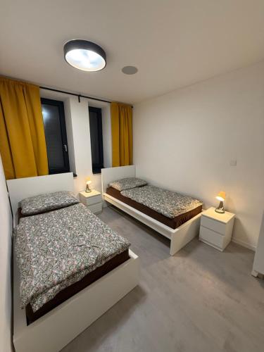 a bedroom with two beds and two lamps on tables at Apartmány pod Chočom, Dolný Kubín in Vyšný Kubín