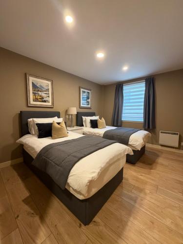 a bedroom with two beds and a window at GRAPHITE APARTMENTS in Inverness