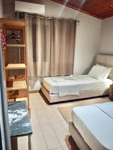 a bedroom with two beds and a window at Villa La Bohème, Nafpliο in Nea Kios