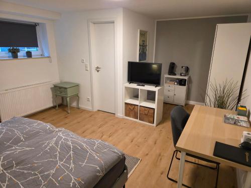 a living room with a bed and a flat screen tv at Apartment Tanne in Düsseldorf