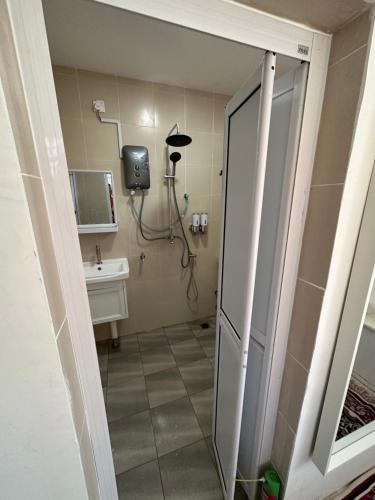 a bathroom with a shower and a sink at Mawar 23 Chendering with Dedicated Pool in Kuala Terengganu